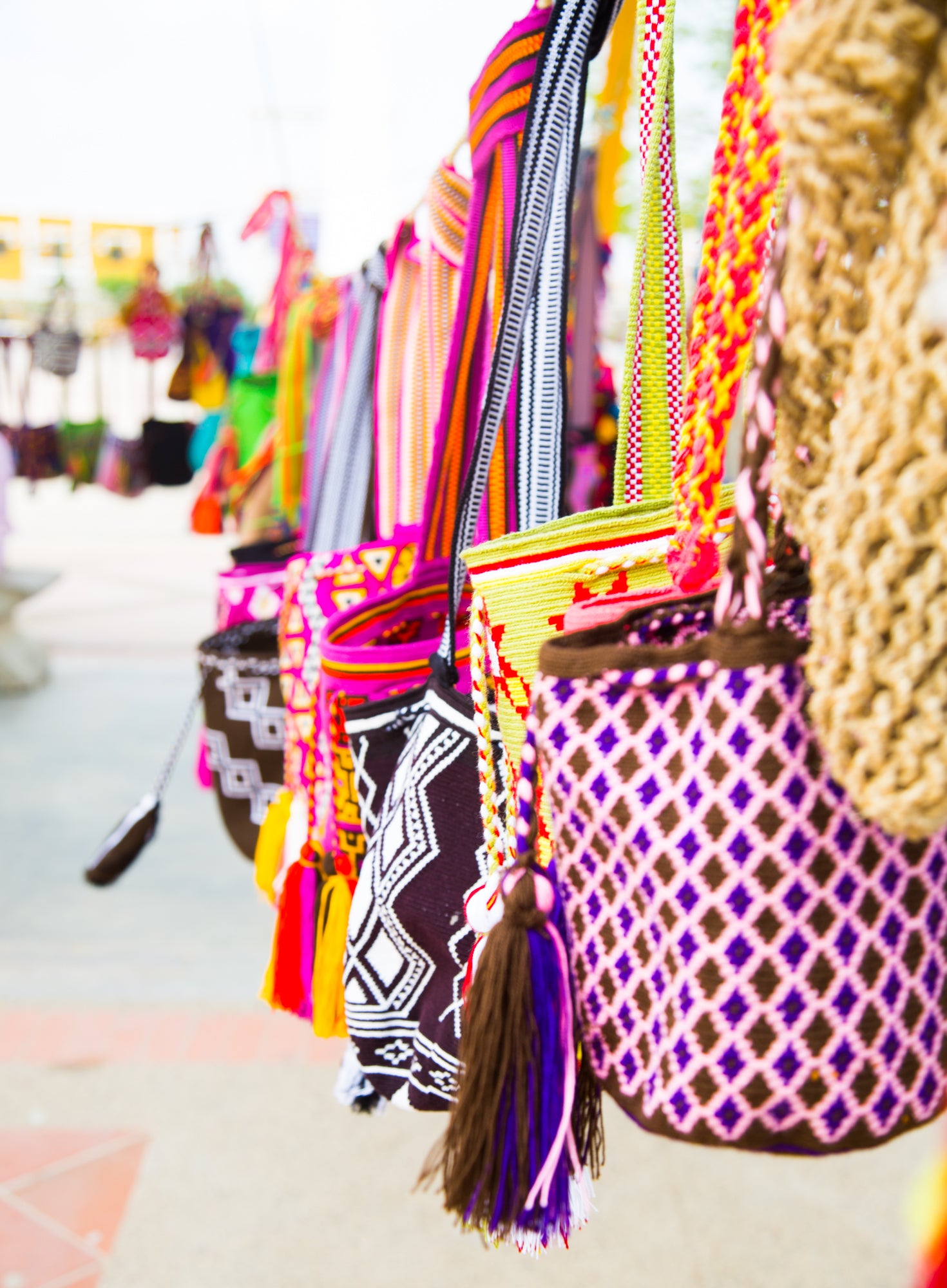 Colorful crochet wayuu bags hanging outside at a store in cabo de la vela